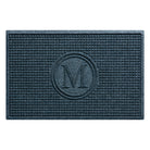 Overhead of a WaterHog Squares outdoor doormat monogrammed with a serif M, encased by two circles surrounded by a uniform grid design in a relaxed blue color; an American-made mat.