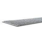 Close up shot of medium grey stair tread with a repeating squares pattern showing its low-profile height and incredibly durable rubber backing.