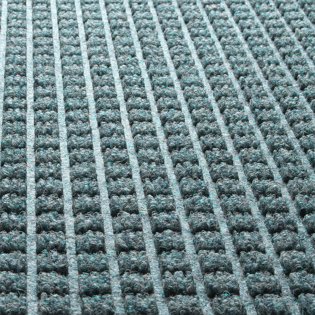 A close-up detailed shot of WaterHog Square's eco-friendly PET surface, made of light blue, grey, white, and some green polyester fibers.