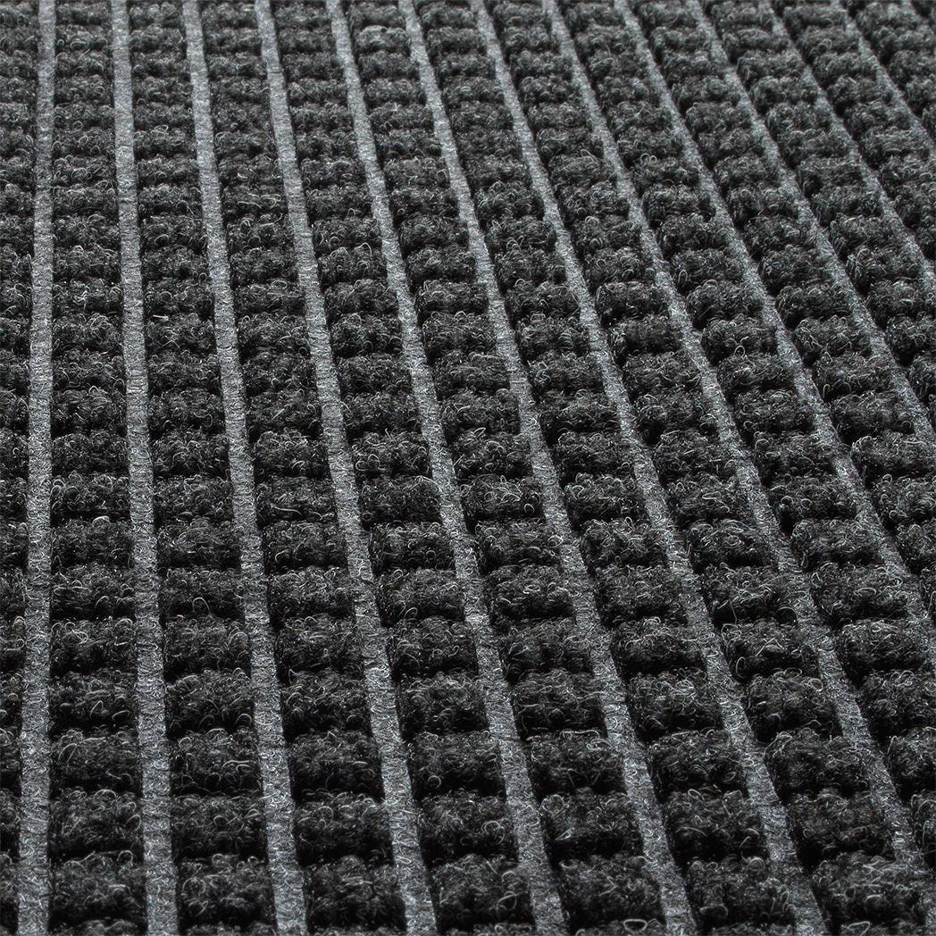 Close-up of WaterHog Squares eco-friendly surface fibers made of various shades of grey to black, with hints of white fibers.