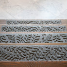 A looking-down perspective over four medium grey Boxwood stair treads on wooden stairs.