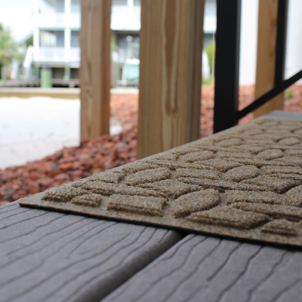 A close-up of WaterHog Ellipse stair tread on an outdoor stair. 