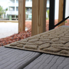 A close-up of WaterHog Ellipse stair tread on an outdoor stair. 