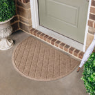 WaterHog exterior mat in a semi-circle shape featuring a classic geometric pattern in a light brown color being used at a single back door to catch and trap dirt, debris, and moisture.