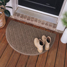 WaterHog Half-Round door mat shown on an all-wood front porch to welcome guests at the door and flanked by green plants and topped by a pair of women's boots.