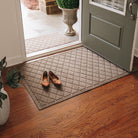 Durable large WaterHog doormat shown in a classic argyle pattern placed inside at a front door on wooden floors with a smaller version placed outside.