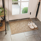 Classic genuine WaterHog doormat in tan/beige canopy bi-level design placed inside by a door with a pair of white sneakers placed on top. 