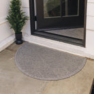 A medium grey half-round doormat, with a diamond design, is placed on tile flooring outside a single door; the door is open to show another doormat of the same color and pattern on the inside  of the door. 