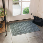 A blue/grey WaterHog High Rise durable dooormat with an elevated chevron-like design displayed on tile floor inside an entrance way.