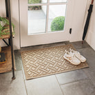 WaterHog Lattice indoor/outdoor mat in tan, featuring a crisscross design, displayed on grey tile flooring in front of a single door, with shoes placed on top.