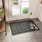 A WaterHog Lattice indoor/outdoor doormat in dark grey, featuring a crisscross pattern, placed on light grey tile flooring in front of a single door.