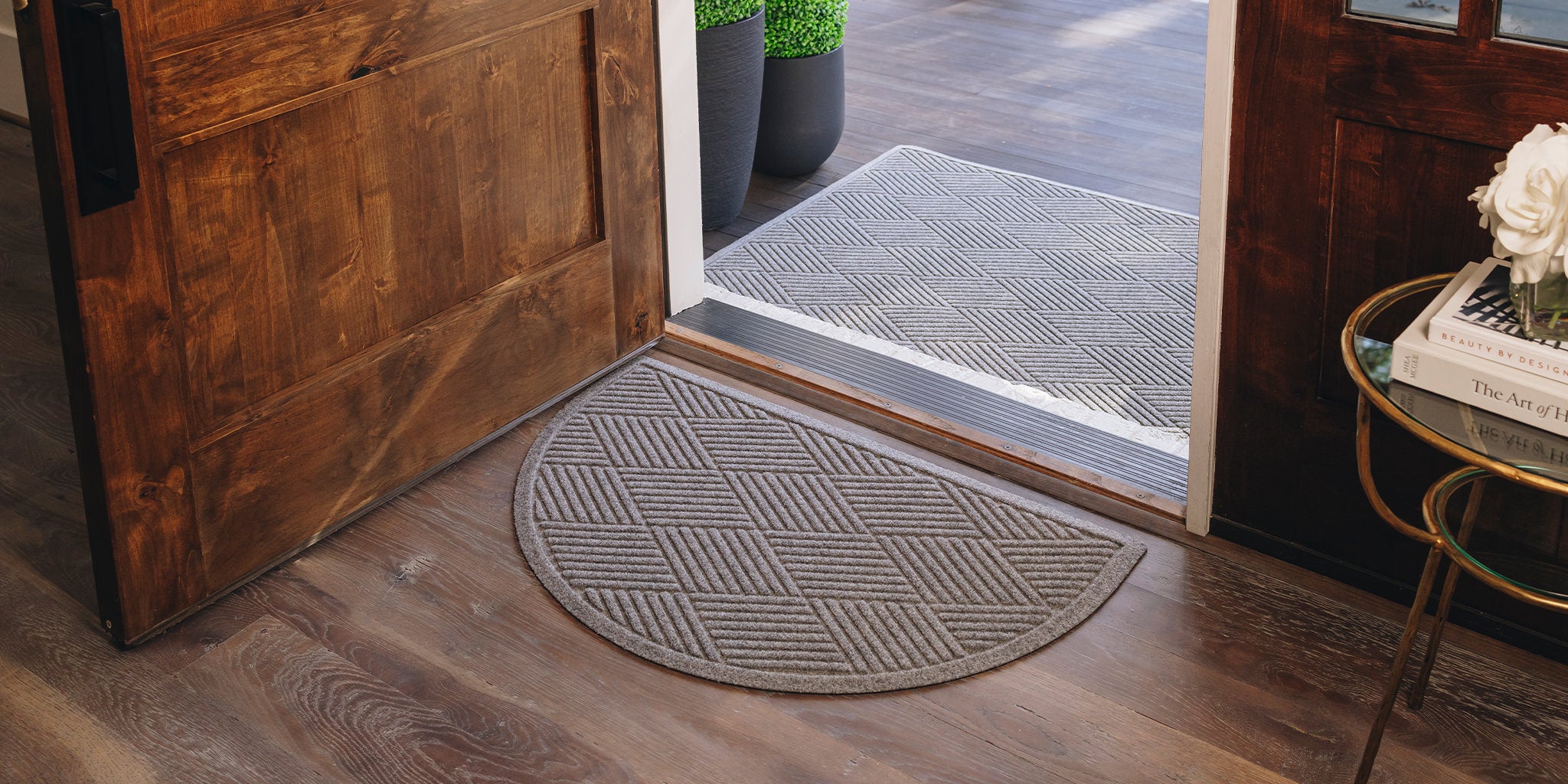 A half round Diamond doormat placed inside a home entryway while a large Diamond doormat is outside as the first layer of door mat protection.