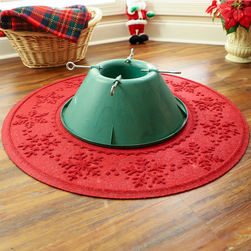 Red Christmas tree skirt with festive snowflake design on a stain-resistant surface, surrounded by holiday decor.