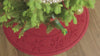 Overhead view of a Christmas tree on a WaterHog Tree skirt that swaps out from Trees to Snowflakes design, shown in red, green, and medium grey
