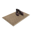 Angled 2x3 WaterHog Argyle doormat in light tan with a pair of brown leather boots placed on top of the stain and fade-resistant surface.