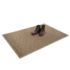 Angled 4x6 WaterHog Argyle doormat in light tan with a pair of brown leather boots placed on top.