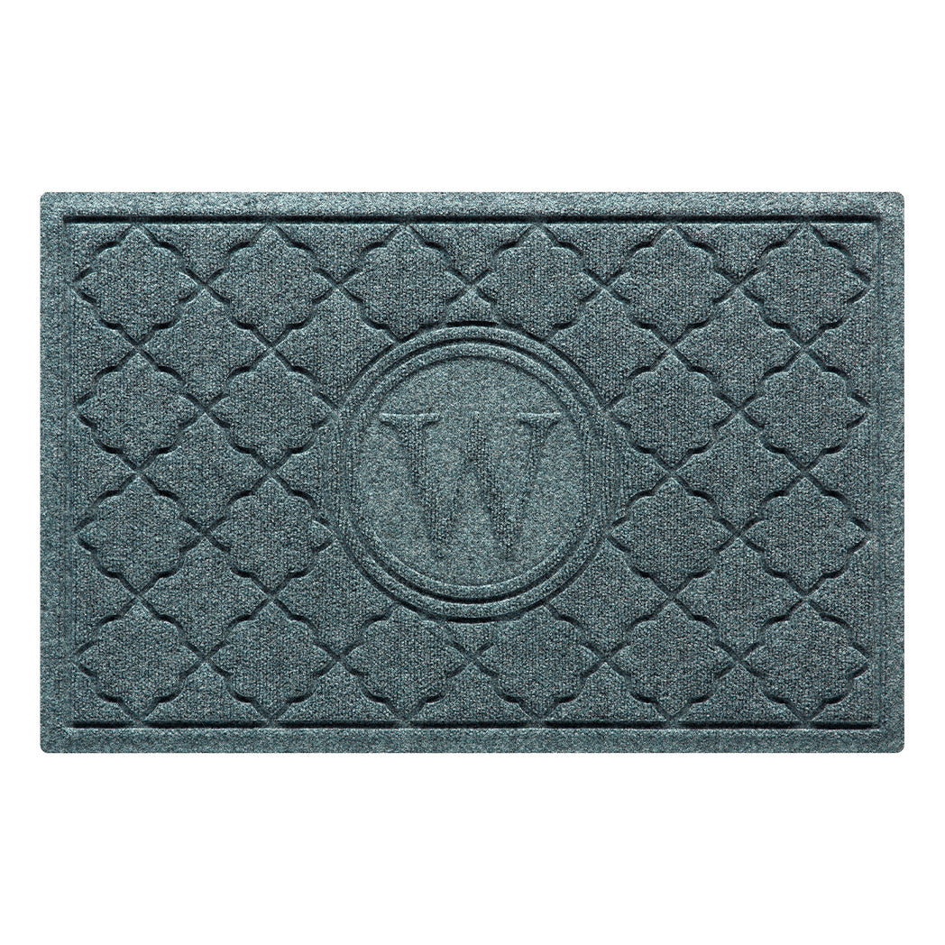 Isolated image of a medium size outdoor WaterHog Bombay Monogrammed Door mat that features a classic repeating geometric pattern with an encircled letter placed in the center; shown in a blue-grey color.