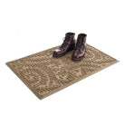 Angled WaterHog a medium Boxwood doormat in camel with a pair of brown leather boots placed on top.