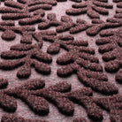 Close-up of Boxwood's surface fibers made of deep wine red, white, and grey fibers pressed to make a leafy design.