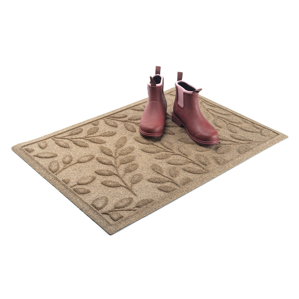 Beautiful and durable genuine WaterHog doormat with leafy bi-level pattern in tan/beige with red rubber boots placed on top. 