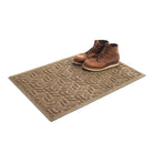 The authentic WaterHog 2x3 indoor/outdoor doormat in camel with a pair of brown boots placed on top on a white background.