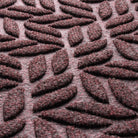 Close-up of WaterHog fibers made of deep wine red, white, and grey fibers pressed to make an aesthetic design.