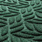 Close-up of Canopy WaterHog door mat with surface fibers made of green, white, and grey creating a repetitive design.