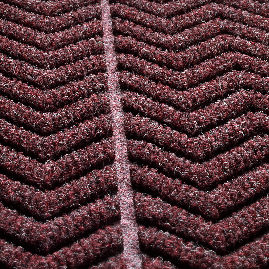 detailed photo of WaterHog chevron surface focusing on the bi-level design and PET fibers in colors red, black, and grey. 