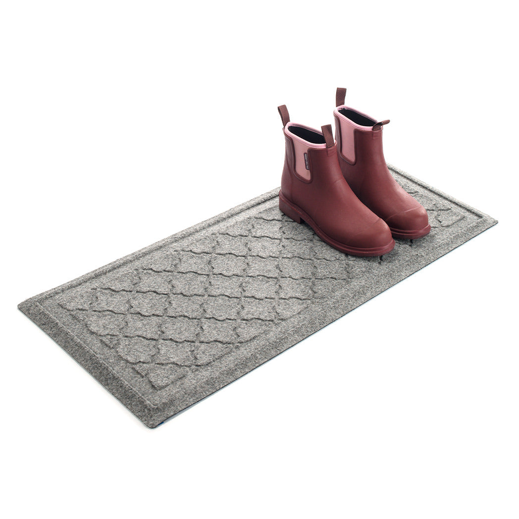 Angled WaterHog 2x3 boot tray with a pair of pink rubber boots in the doormat on a white background.