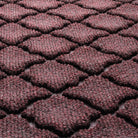 Close-up of Cordova's surface fibers made of deep wine reds, whites, and greys, pressed to make an aesthetic design.