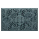 Personalized WaterHog 2x3 Deanna monogram doormat in a light blue/grey leafy design on a stain-resistant surface.