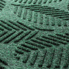 Close-up of the all-weather WaterHog door mat with fibers made of green, white, and grey creating a leafy design.