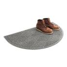 Isolated WaterHog Diamonds half-round doormat in medium grey with a pair of brown leather boots on the doormat.