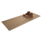 Isolated Angle of 2x5 runner shown in the color camel with a pair of men's boots on top on a white background.