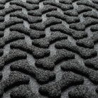 Close-up of WaterHog's Dog Bone's tough surface made of various shades of grey to black, with hints of white fibers.