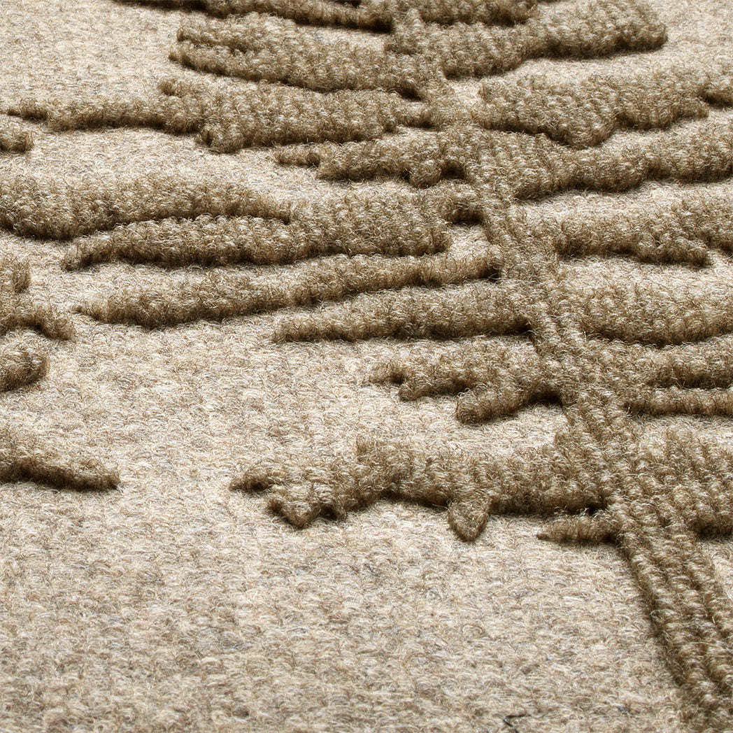 A close up shot of the WaterHog Fir Lineup outdoor doormat in a camel color, showing the bi-level design that allows for easy scraping.