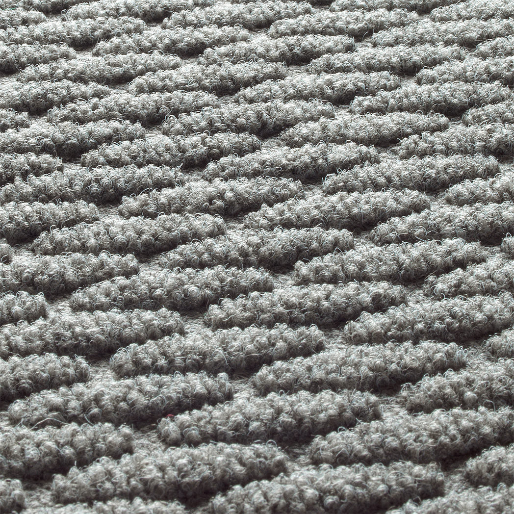 A close-up photo of the carpeted top of a WaterHog Hampton doormat displaying the bi-level scrapping surface.