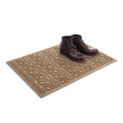 The premium WaterHog 2x3 all-weather doormat in camel with a pair of boots placed on top on a white background.