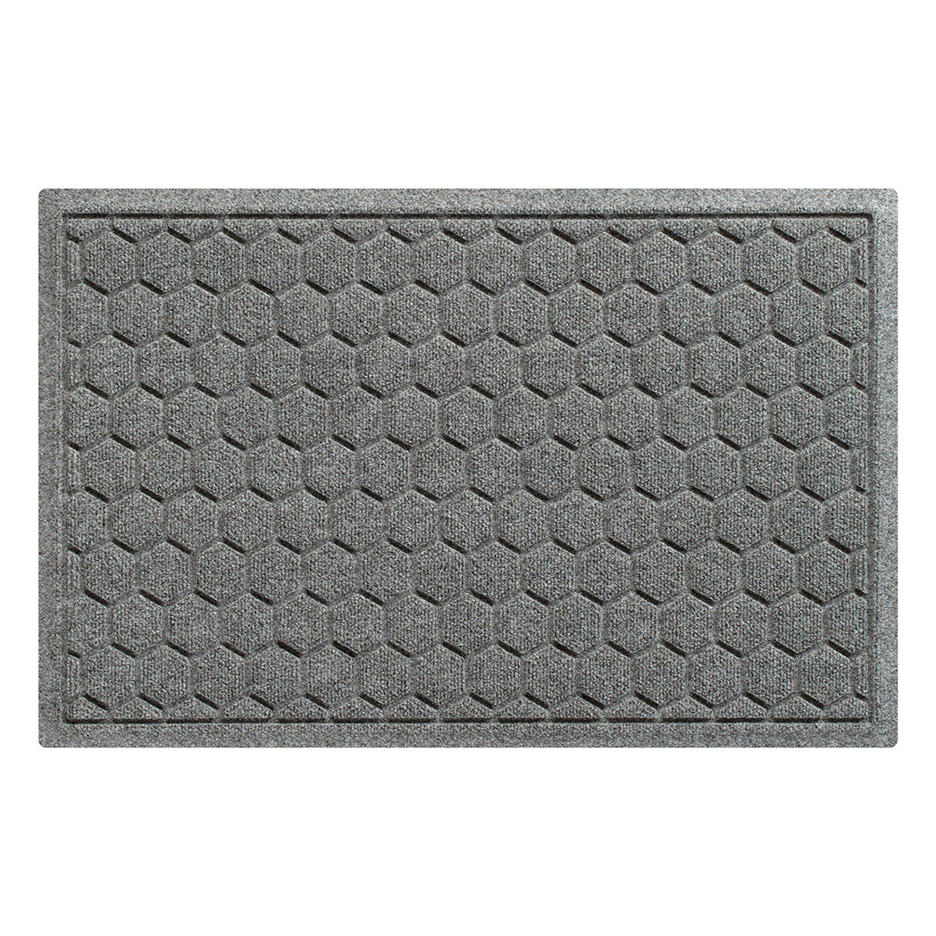 A WaterHog Honeycomb all-weather doormat in light grey, featuring a hexagonal pattern displayed on a white background.