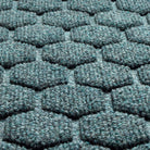 A close-up shot of the WaterHog Honeycomb outdoor doormat in blue/grey, displaying the carpeted fibers that form the raised hexagonal pattern.