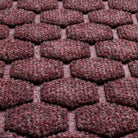 A close-up shot of the WaterHog Honeycomb all-weather doormat in maroon, displaying the fibers that make up the raised hexagonal pattern.