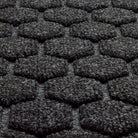 A close-up shot of the WaterHog Honeycomb all-weather doormat in dark grey, displaying the carpeted fibers that form the raised design.