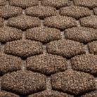 A close-up shot of the WaterHog Honeycomb all-weather doormat in dark brown, displaying the carpeted fibers that form the raised design.