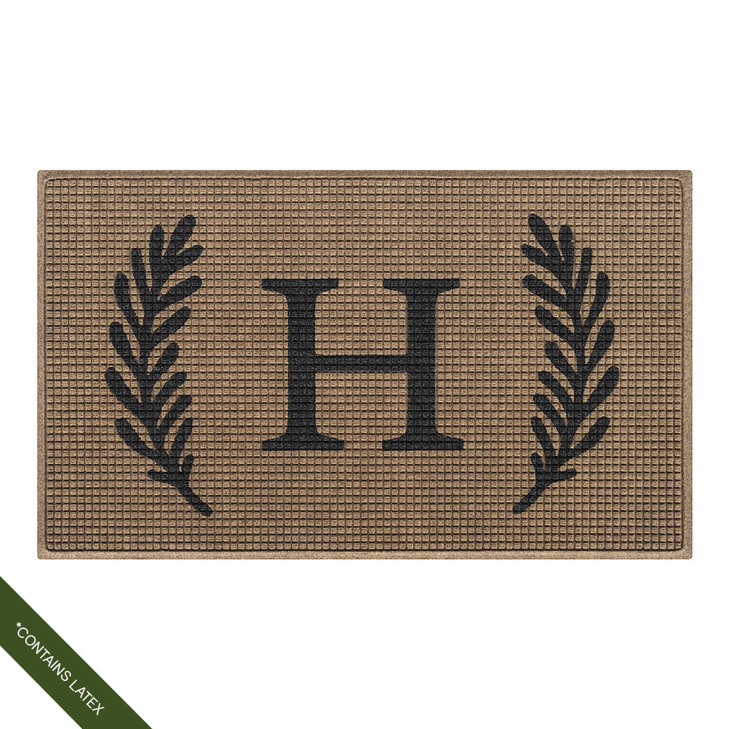 Large 3'x5' charcoal WaterHog Squares doormat personalized with a capitalized serif 'H' in charcoal with a laurel design; latex declaimer