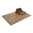 A premium WaterHog 2x3 Lattice all-weather doormat in camel with a pair of brown leather boots placed on top.