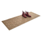 An outdoor WaterHog Lattice 2x5 runner mat in camel with a set of clean boots resting on top  on a white background.