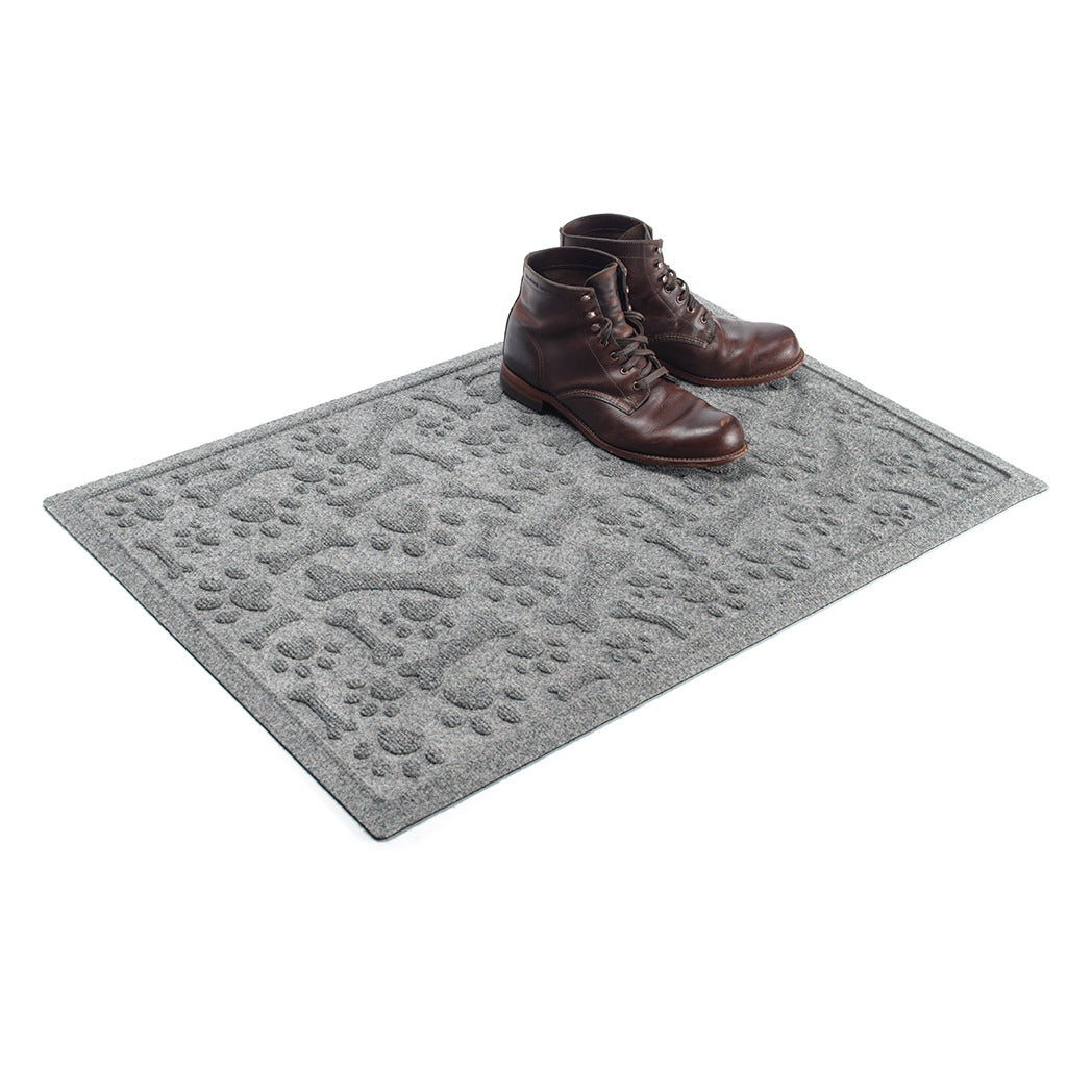 WaterHog Paws & Bones 2x3 in light grey, featuring a scattered design of animal paw prints and bones, with boots placed on the mat.