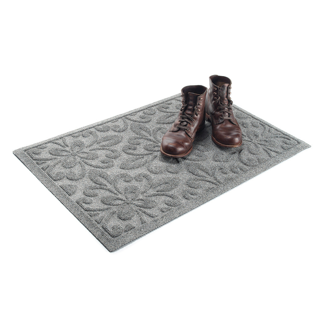 WaterHog Phoenix 2x3 indoor/outdoor doormat in light grey, featuring a quad pedal floral design, with boots placed on the mat.