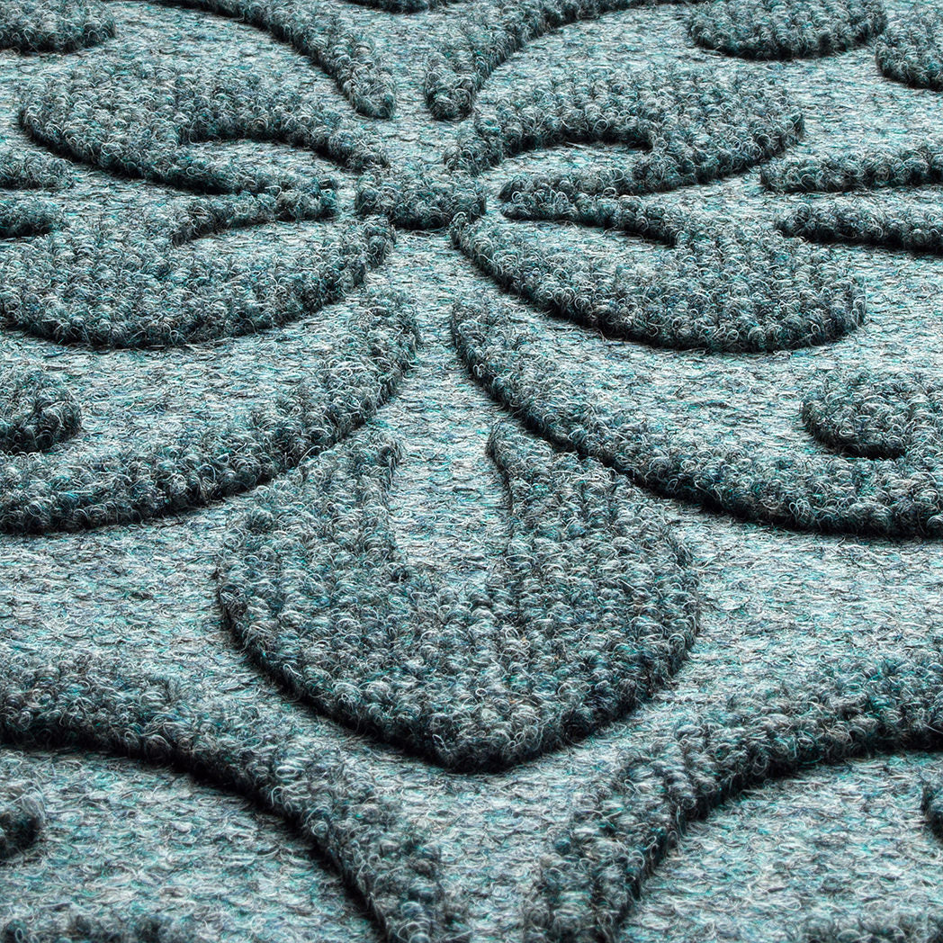 A close-up shot of the WaterHog Pheonix Indoor/Outdoor doormat in a grey/blue, displaying the mixture of blue, grey, and white carpeted fibers that make up the top of the mat.