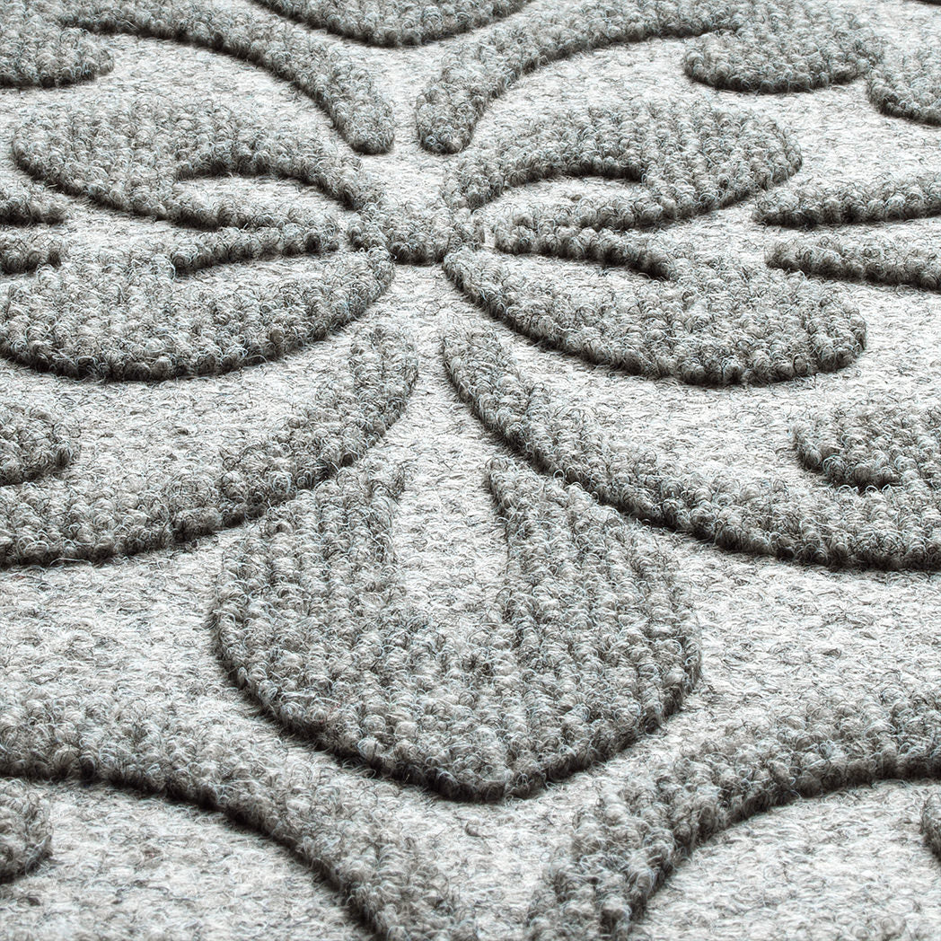 close-up shot of the WaterHog Pheonix Indoor/Outdoor doormat in light grer, displaying the mixture of grey and white carpeted fibers that make up the top of the mat.